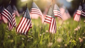 A close up look at American flags planted in green grass.