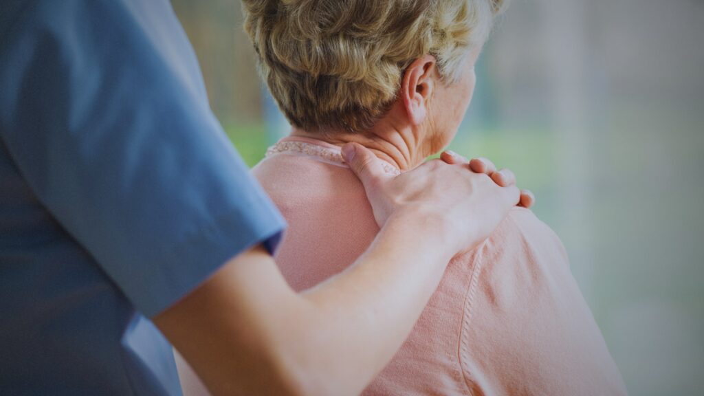 Redlands Nursing Home nurse placing their hand on the patient's shoulder