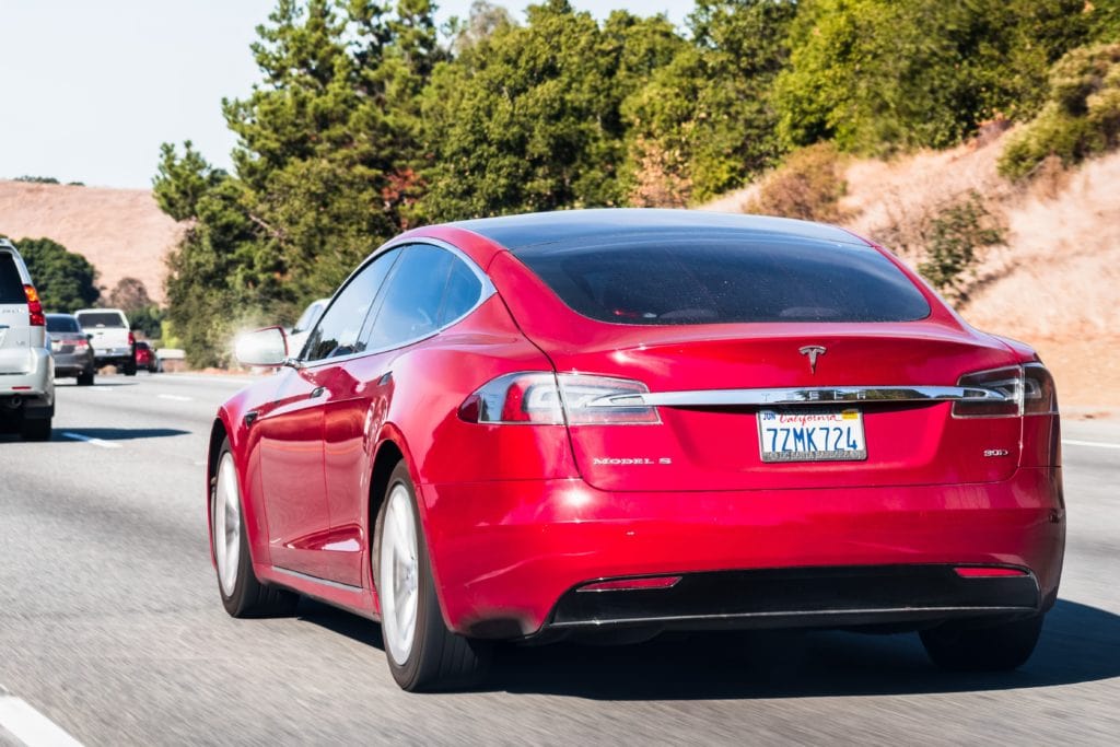 Red Tesla Model S driving on highway