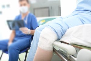 Doctor Examining X-Ray with Leg Injury Patient