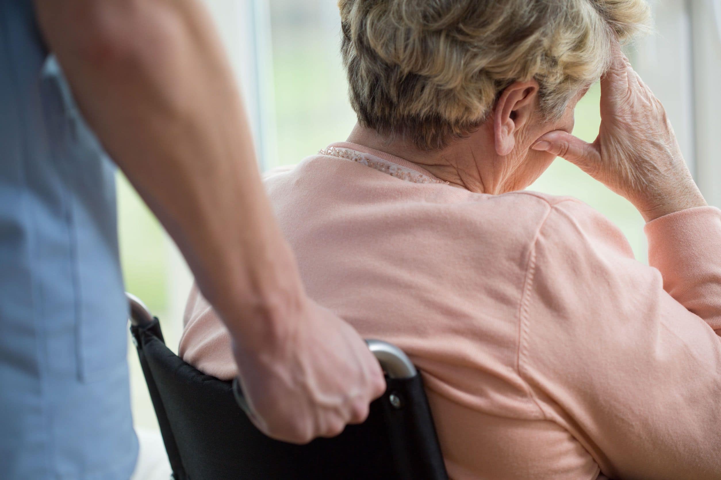 nurse pushing senior citizen in wheelchair